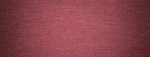 Dark red background from textile material with wicker pattern, and vignette. Structure of wine fabric with texture.