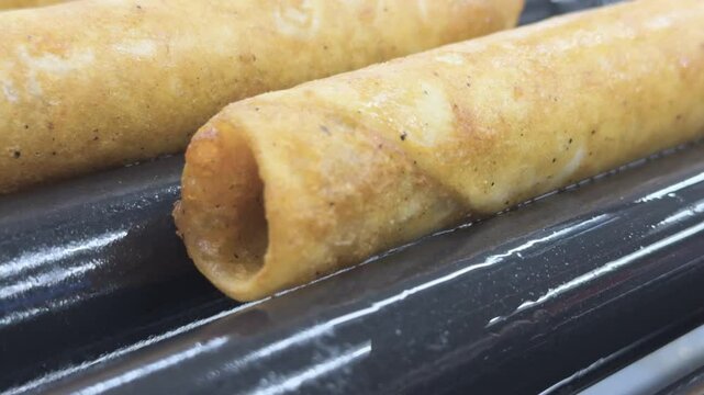 Close up on grill roller items spinning while cooking 4k