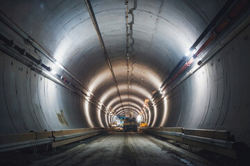 Construction progress in an underground tunnel with illuminated walls and machinery view