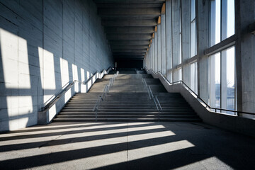 Modern architectural stairway with geometric lines and natural light in a concrete building interior