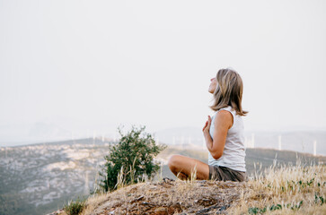 Woman practicing mindfulness and gratitude with a scenic background