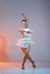 Elegant female Latin dancer in a white fringed dress performing a dynamic move with grace and...