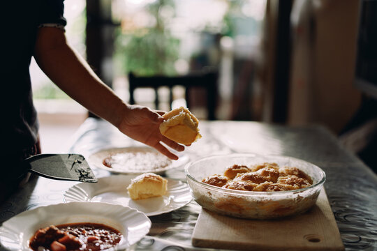 Housewife puts pampushka on a plate next to a plate of borscht