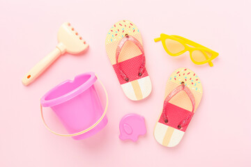 Children's flip-flops and beach toys on color background,,top view