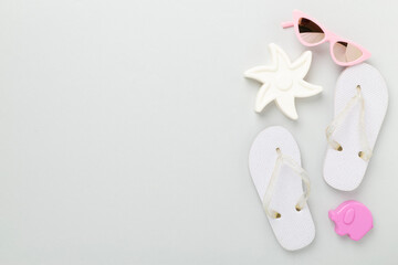 Children's flip-flops and beach toys on color background,,top view