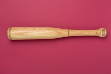 Wooden baseball bat on color background, top view