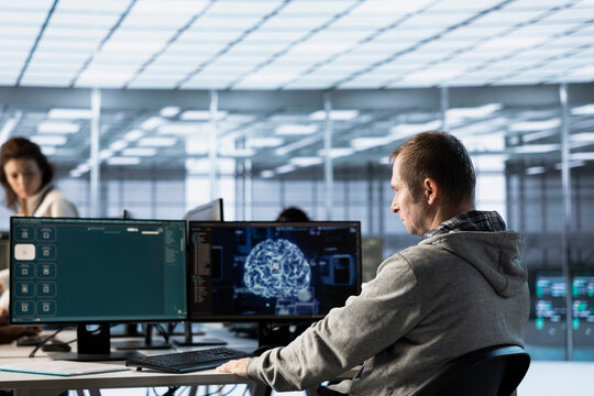 Computer scientist in data center coding AI LLM chatbo answering user prompts using predictive technology. Server room employee building large language model program using artificial intelligence - Powered by Adobe