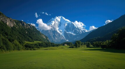 Majestic snow-capped mountain peak overlooking a lush green valley.