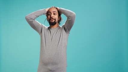 Disappointed man admonishing friend over debacle, isolated over blue studio background. Upset...