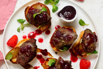 Crostini with chicken liver, caramelized pear and raspberry sauce.top veiw