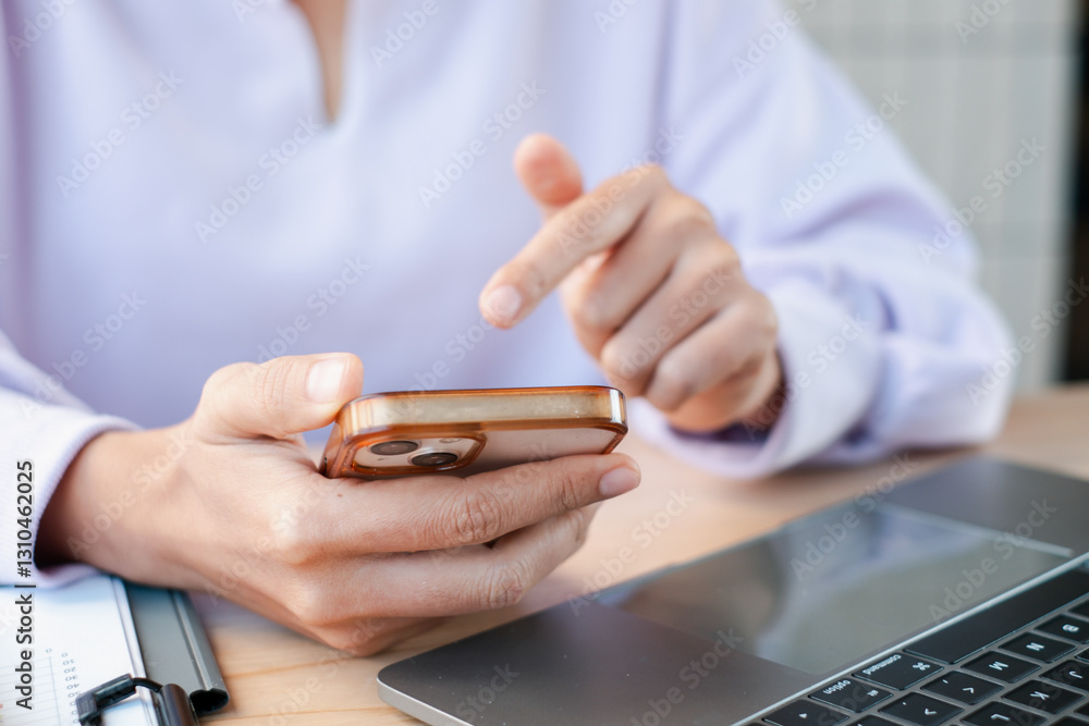 Poster hands interacting with a smartphone and laptop, showcasing technology use in a professional environm