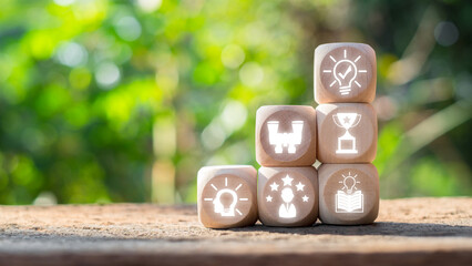 Wooden blocks with icons symbolizing success and achievement, set against a natural background,...