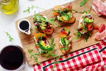 Crostini with ham, cream cheese and arugula. on the cutting board. selective focus