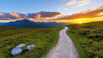 Winding dirt path through lush green hills under a vibrant sunset