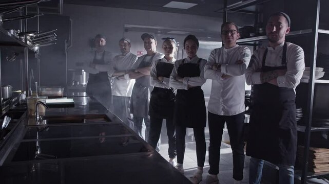 Confident cooks standing with arms crossed in kitchen