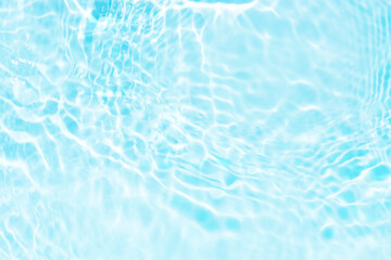 Blue water with ripples on the surface. Defocus blurred transparent blue colored clear calm water surface texture with splashes and bubbles. Water waves with shining pattern texture background.