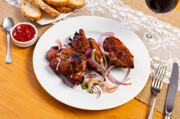 Grilled lamb kebab - meat dish, with greens and onion on white plate. Popular oriental dish