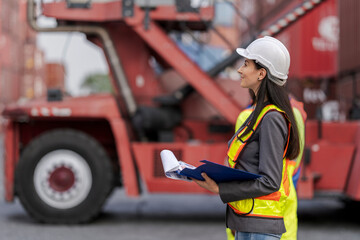 Fototapeta premium Team logistics workers in high visibility safety gear and hard hats discuss operations at a busy shipping container yard. Team multi nationality working together on site container warehouse.