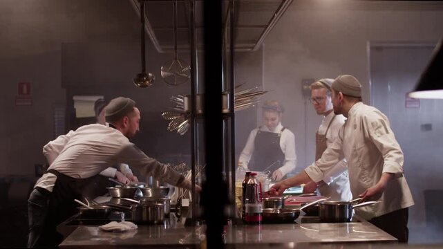 Chefs preparing food in commercial kitchen restaurant