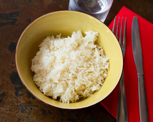 Cooked white rice in bowl closeup, food concept