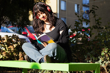 teenage girl sitting in the park reading a book
