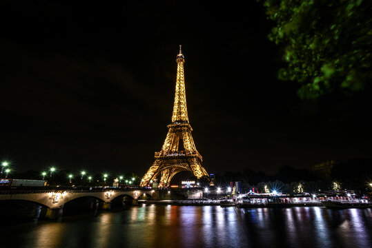 Golden Lights of the Eiffel Tower Reflecting on the Seine at Night - Paris, France