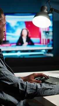Vertical Video African american man working on PC to write code and programming in artificial intelligence and deep learning. Male IT engineer using pc to ensure cyber security, neural network. Camera