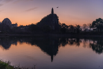 Obraz premium Pagoda and the city buildings surrounded by the limestone mountains