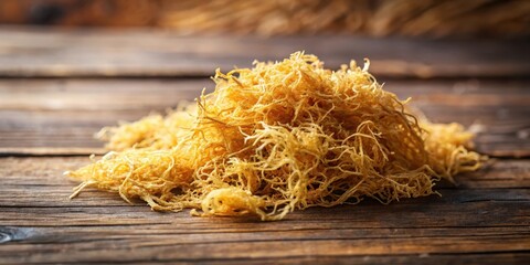 Dried golden sea moss with intricate texture and natural color tones on a wooden background, seaweed, aquatic life