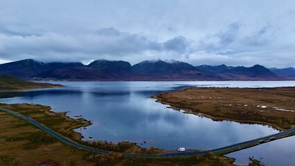 Motorhome driving beside Calm Mountain Lake with Reflection and Scenic View in Fjord Norway
