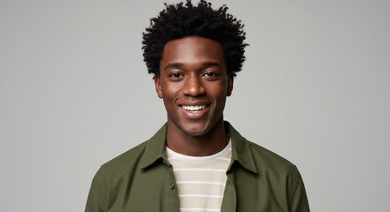 Obraz premium Waist-up studio portrait of a young male model looking into the camera with a cheerful expression. He is wearing a T-shirt and an overshirt.