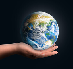 Planet in our hands. Woman holding glowing Earth on dark blue background, closeup
