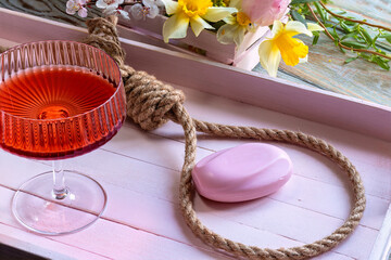 Noose and soap. Symbol suicide. In pink tones. Concept of life crisis. Femininity, spring flowers....