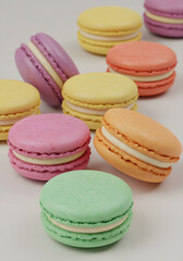 Obraz premium Colorful macarons with creamy filling in pastel hues of yellow, purple, pink, and green