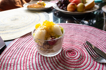 Dessert in a restaurant, fruits on the table in a plate. Fruit salad with yogurt.