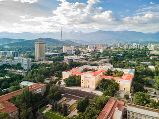Aerial view of the historical center of Almaty with a focus on the Kazakh Academy of Sciences. Spring morning, with mountains and the city's main landmarks visible in the background.