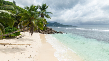 A sandy beach surrounded by tropical flora. Mahe, Seychelles.