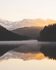 Obraz premium Serene Mountain Reflection in Calm Lake at Dawn with Soft Mist