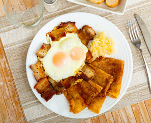 National german pancakes with pork meat, served with fried eggs, on a table in a cafe