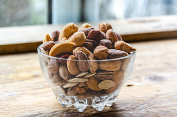 Assorted nuts in glass bowl on kitchen table