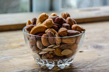 Assorted nuts in glass bowl on kitchen table