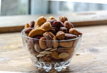 Assorted nuts in glass bowl on kitchen table