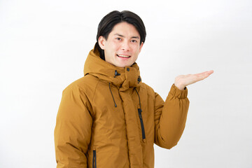ダウンジャケットを着た男性　右側を手のひらで指す　白背景