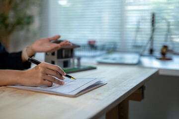 A woman is writing on a piece of paper with a pen