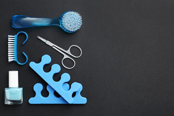 Set of pedicure tools on black background, flat lay. Space for text
