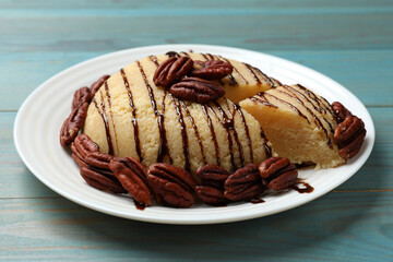 Delicious sweet semolina halva with pecans on blue wooden table, closeup