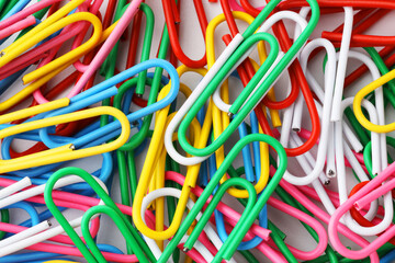 Many colorful paper clips on white background, top view