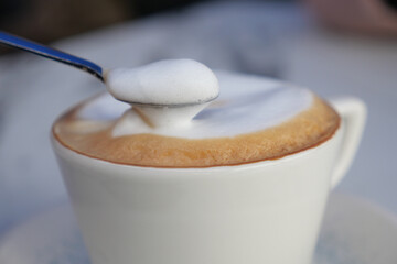 Creamy foam topping on a coffee cup served outdoors in daylight
