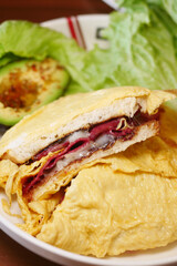 Delicious sandwich loaded with ingredients and served with vegetables
