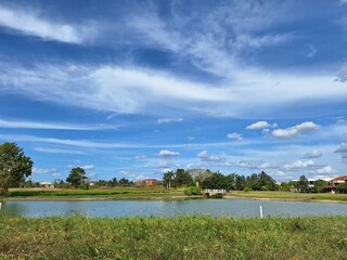 Landscape with lake, blue sky, and white clouds.